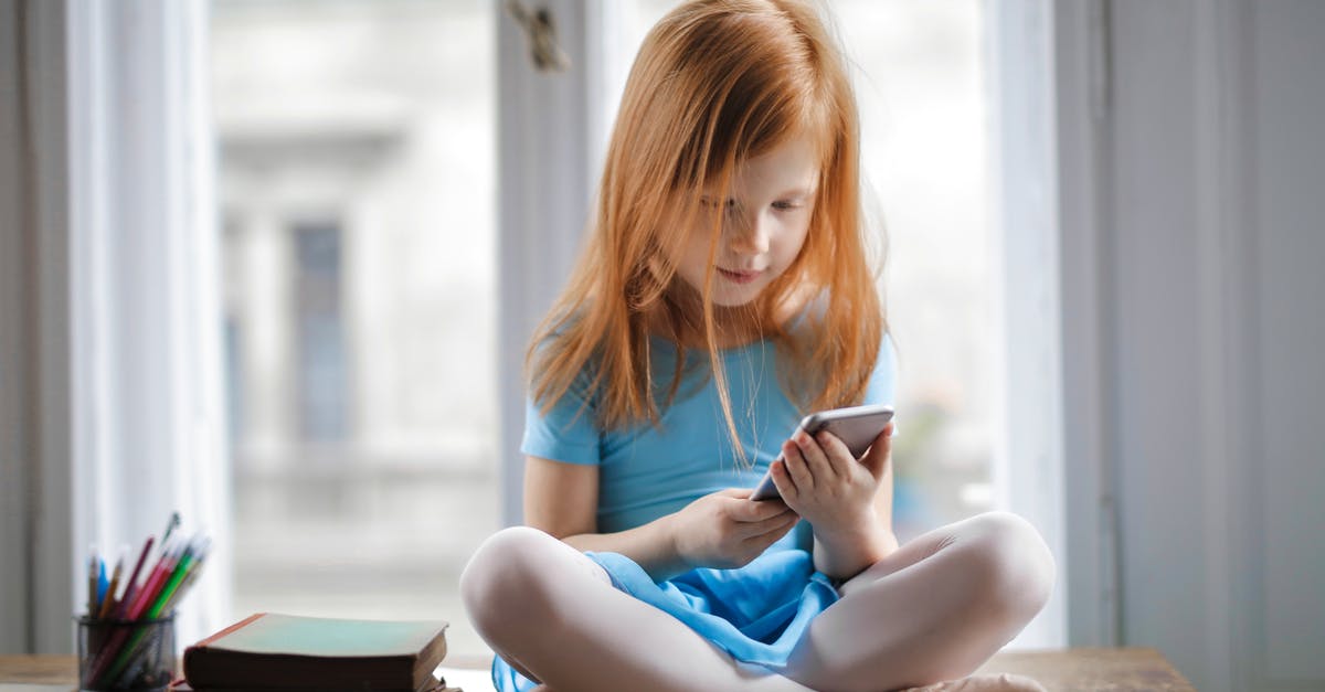How do I remove small grounds when using a french press? - Red haired charming schoolgirl in blue dress browsing smartphone while sitting on rustic wooden table with legs crossed beside books against big window at home How do I remove small grounds when using a french press? - Red haired charming schoolgirl in blue dress browsing smartphone while sitting on rustic wooden table with legs crossed beside books against big window at home