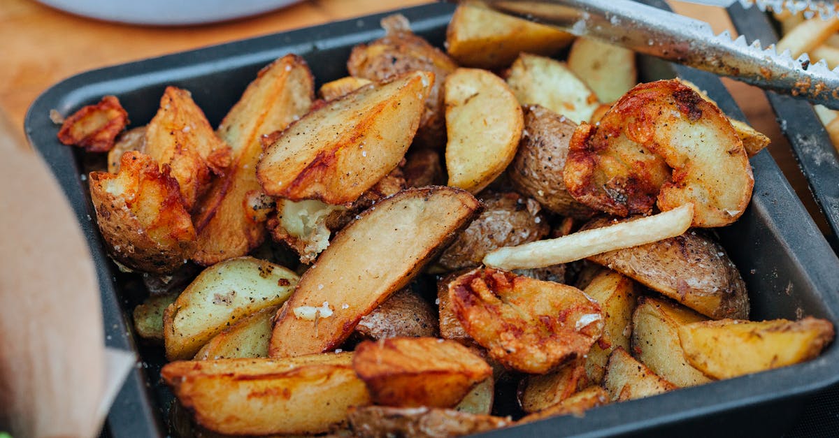 How do I season potato wedges or quartered roasted potatoes with 'Leon's Baked Fries'? - Potato Wedges on a Metal Tray 