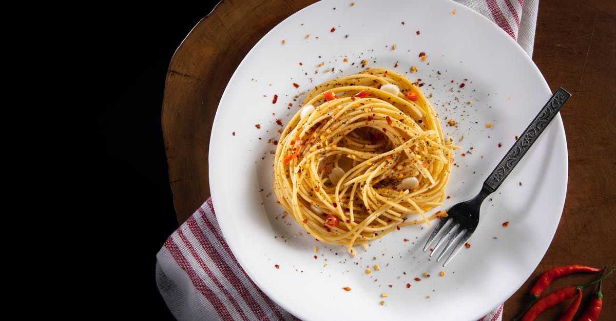 How do I tone down the flavor of garlic in spaghetti sauce - Top view of tasty noodles with garlic and chili pepper slices decorated with ground pepper mix on table in cafe How do I tone down the flavor of garlic in spaghetti sauce - Top view of tasty noodles with garlic and chili pepper slices decorated with ground pepper mix on table in cafe