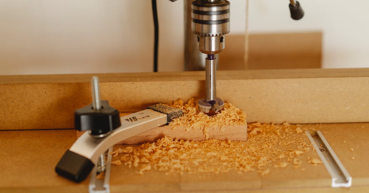How do I use my lever press correctly? - Electric drill press making hole in timber plank fixed with carpenter vice on workshop table