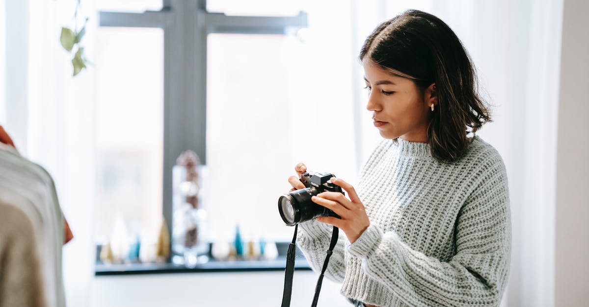 How do I use my lever press correctly? - Side view of young Latin American woman taking photo of clothes on camera in house