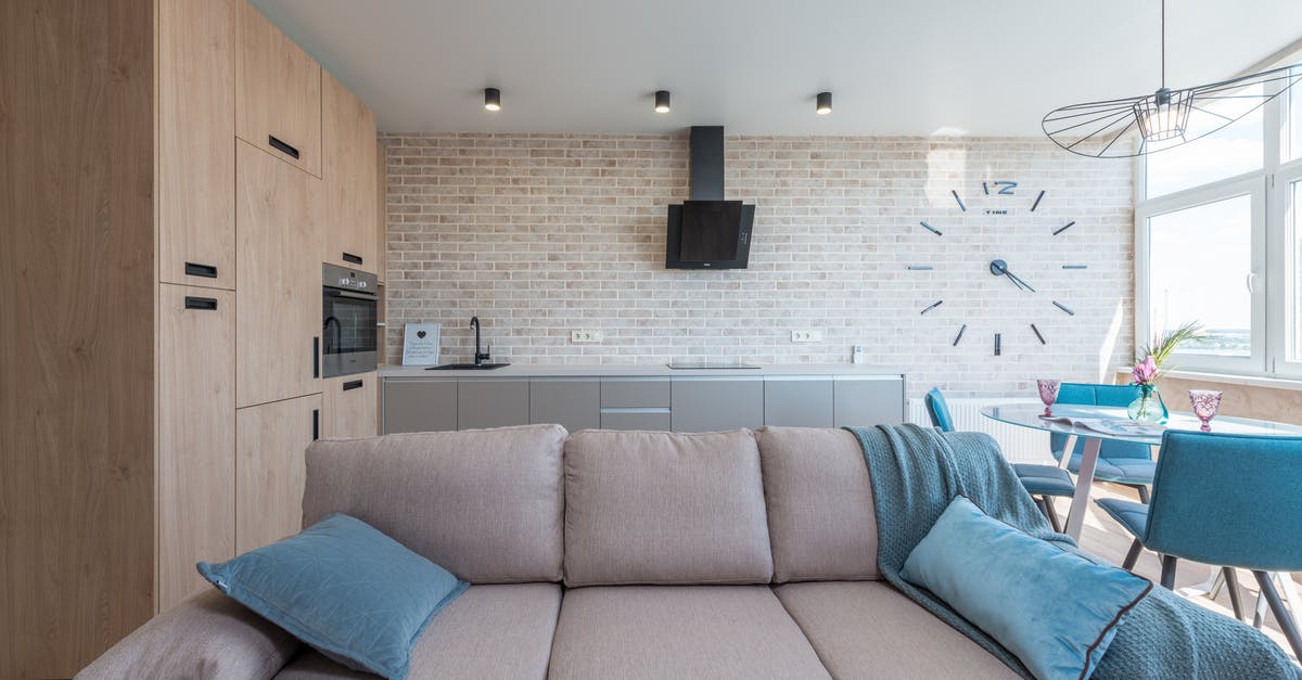 How do I use the clock on my Ilve oven? - Minimalistic interior design of modern light studio consisting of big sofa and kitchen with dining table and chairs against brick wall in daylight How do I use the clock on my Ilve oven? - Minimalistic interior design of modern light studio consisting of big sofa and kitchen with dining table and chairs against brick wall in daylight