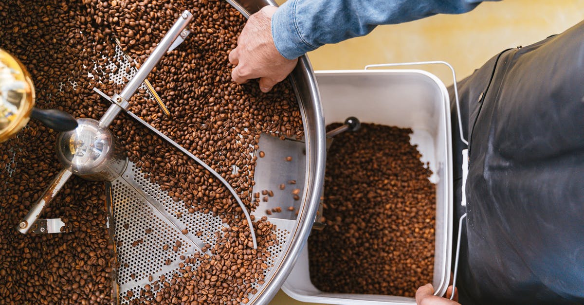 How do they get caffeine out in decaffeinated coffee? - A Person Holding a Bucket while Getting Coffee Beans From the Machine How do they get caffeine out in decaffeinated coffee? - A Person Holding a Bucket while Getting Coffee Beans From the Machine
