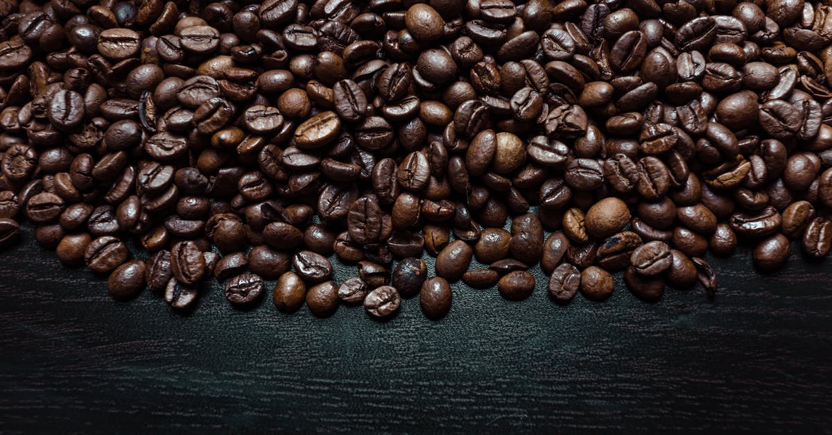 How do we keep our roasted cashews from smelling bad eventually? - Top view of bright crispy halves of coffee beans with pleasant smell on black surface