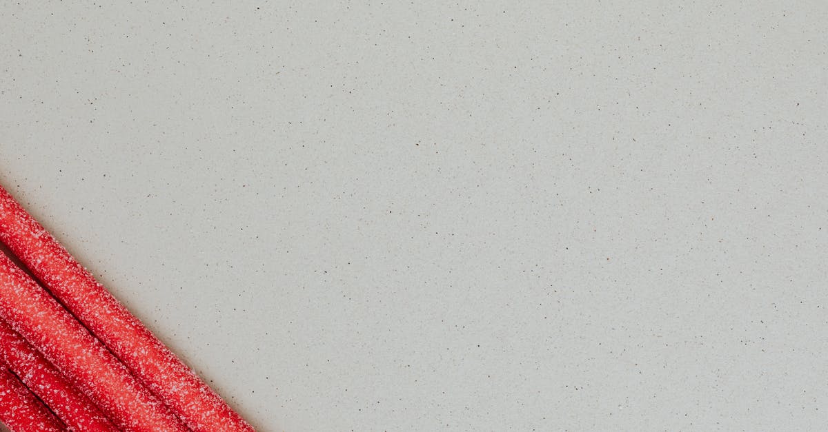 How do you form Marshmallow Ropes? - Long red chewy marmalade candy on gray background How do you form Marshmallow Ropes? - Long red chewy marmalade candy on gray background