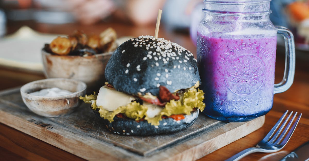 How do you grill a perfect burger? - Delicious hamburger and mug of cold smoothie on wooden board How do you grill a perfect burger? - Delicious hamburger and mug of cold smoothie on wooden board