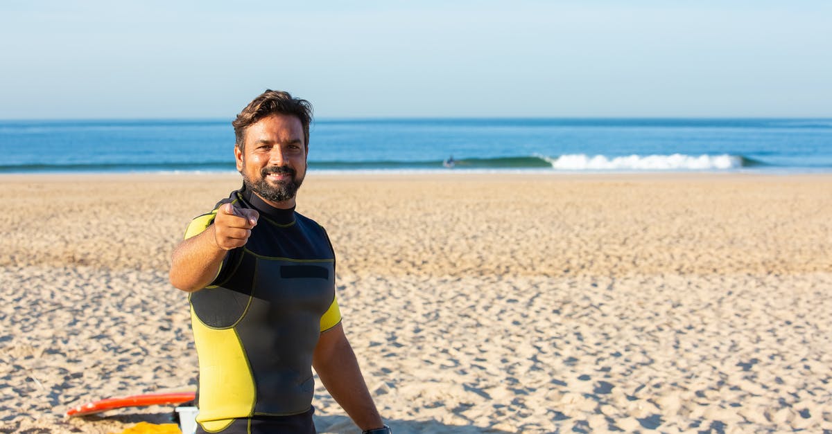 How do you make mustard water? - Happy male in diving suit looking and pointing at camera while standing on beach in bright sunny day How do you make mustard water? - Happy male in diving suit looking and pointing at camera while standing on beach in bright sunny day