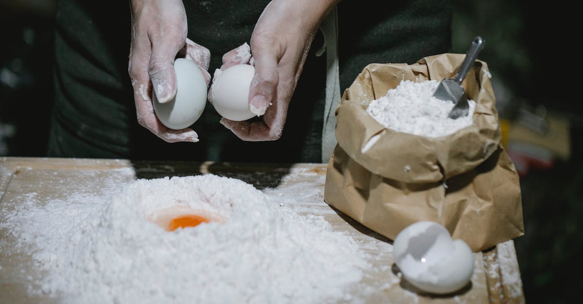 How do you make the wishbone break easier? - High angle of crop anonymous chef breaking eggs for cooking dough at table with flour How do you make the wishbone break easier? - High angle of crop anonymous chef breaking eggs for cooking dough at table with flour