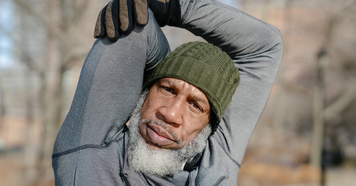 How do you raise your dough in cold seasons? - Black elderly male stretching arms in park in autumn How do you raise your dough in cold seasons? - Black elderly male stretching arms in park in autumn