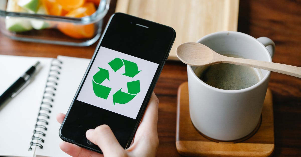 How do you reduce static in a coffee grinder? - Crop person using recycling app on smartphone against coffee