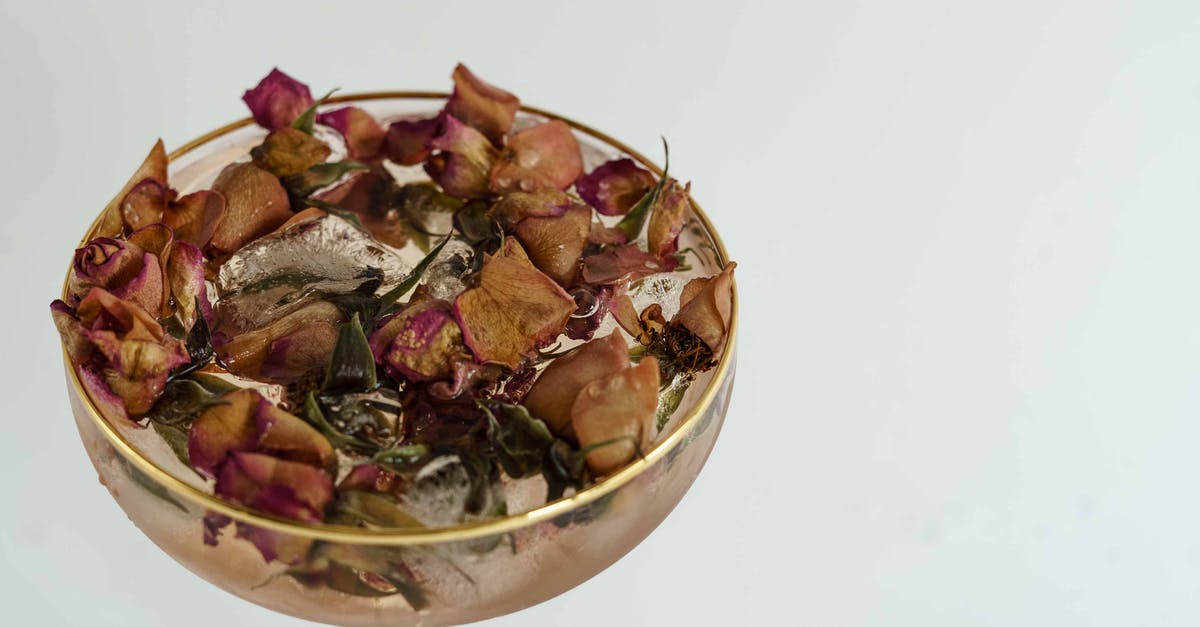How do you thicken a cold filling? - High angle of coupe glass filled with cold cocktail with dried herbs on white background