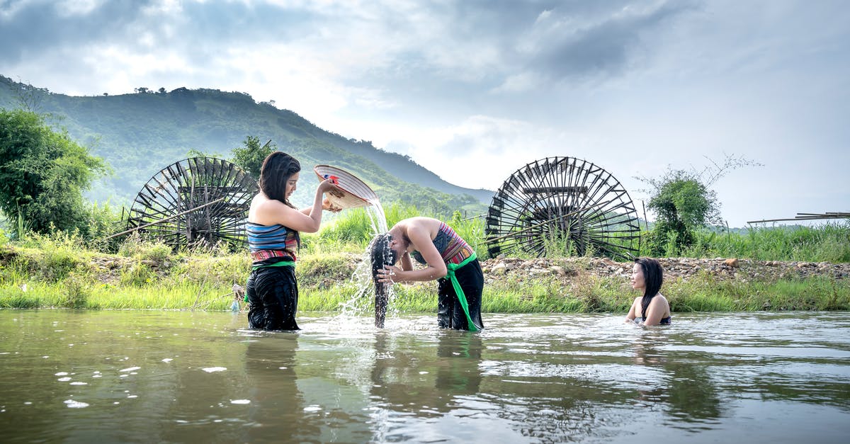 How does a splash of vinegar help when poaching eggs? - Ethnic woman pouring water on head of female in river How does a splash of vinegar help when poaching eggs? - Ethnic woman pouring water on head of female in river