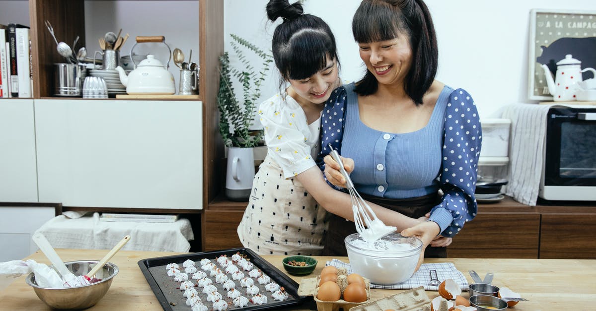How does a splash of vinegar help when poaching eggs? - Happy Asian mother and daughter cuddling while preparing meringues in kitchen How does a splash of vinegar help when poaching eggs? - Happy Asian mother and daughter cuddling while preparing meringues in kitchen
