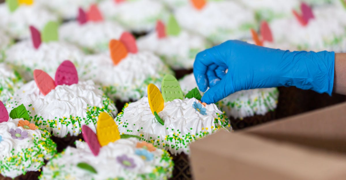 How does a whipped cream charger work? - Crop unrecognizable worker in disposable glove with box against tasty desserts with egg and floral decor on whipped meringue cream How does a whipped cream charger work? - Crop unrecognizable worker in disposable glove with box against tasty desserts with egg and floral decor on whipped meringue cream