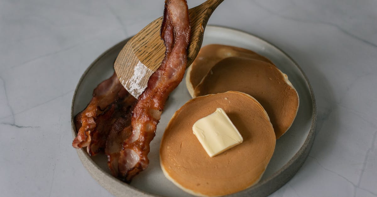 How does butter remain edible for so long without refrigeration? - High angle of delicious pancakes with butter piece near sliced fried bacon and wooden kitchen spatula on plate on white table in bright place How does butter remain edible for so long without refrigeration? - High angle of delicious pancakes with butter piece near sliced fried bacon and wooden kitchen spatula on plate on white table in bright place