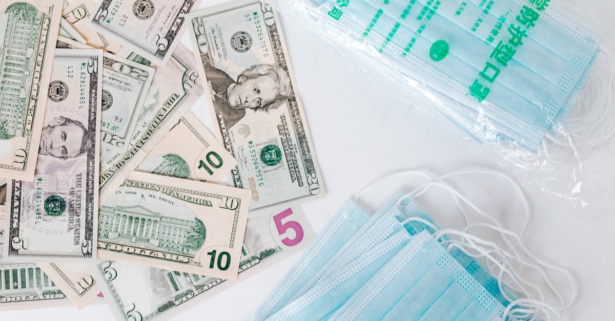 How does produce grading in the US work? - From above composition of stack of USA dollar bills placed near medical protective masks produced in China illustrating concept of medical expenses and deficit during COVID 19 How does produce grading in the US work? - From above composition of stack of USA dollar bills placed near medical protective masks produced in China illustrating concept of medical expenses and deficit during COVID 19