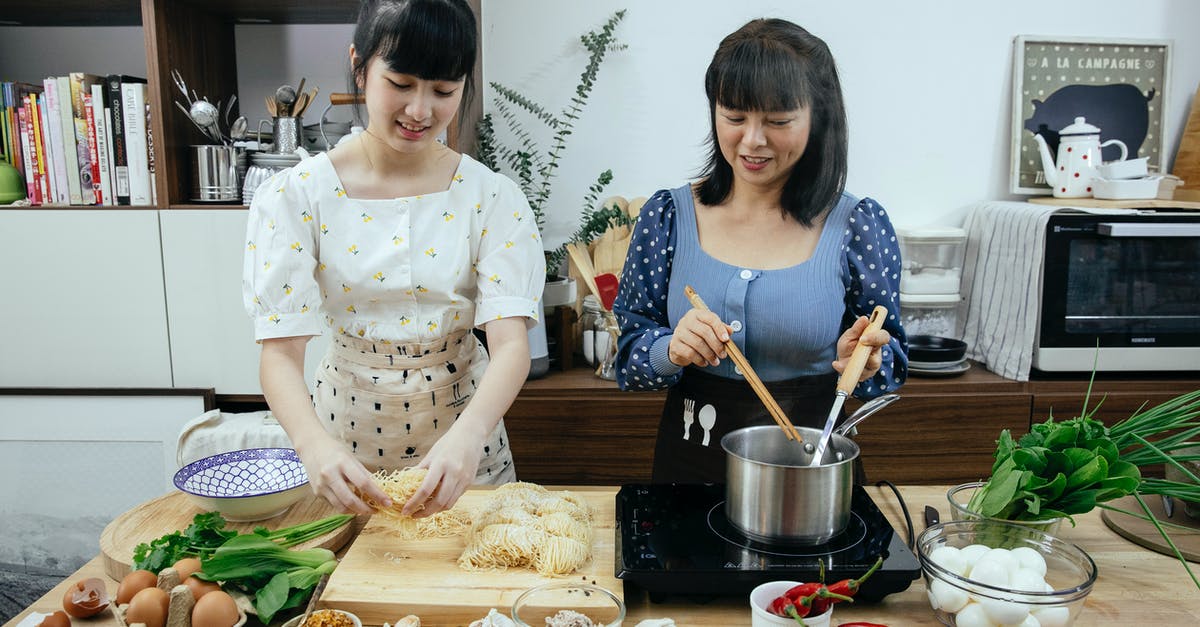 How does removing the germ of garlic help with breath/digestion? - Asian women cooking homemade egg noodles in kitchen How does removing the germ of garlic help with breath/digestion? - Asian women cooking homemade egg noodles in kitchen