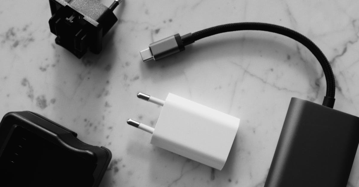 How does the power setting on a microwave work? - Composition of various modern charging units with adapter and small black external battery with short cable placed on white marble table