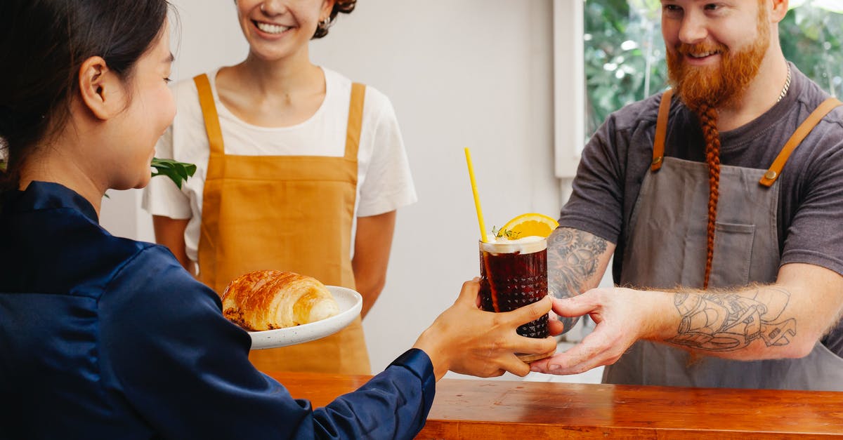 How does velveting work? - Crop cheerful workers passing tasty pastry and glass of alcoholic beverage to ethnic partner at counter How does velveting work? - Crop cheerful workers passing tasty pastry and glass of alcoholic beverage to ethnic partner at counter
