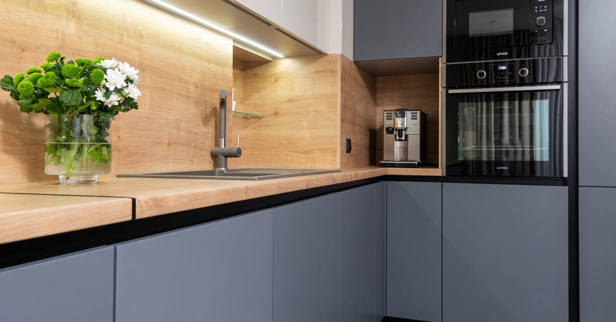 How does water behave in Dutch oven baking? - Cabinets with coffeemaker against oven and table with blooming flowers in vase in modern kitchen How does water behave in Dutch oven baking? - Cabinets with coffeemaker against oven and table with blooming flowers in vase in modern kitchen