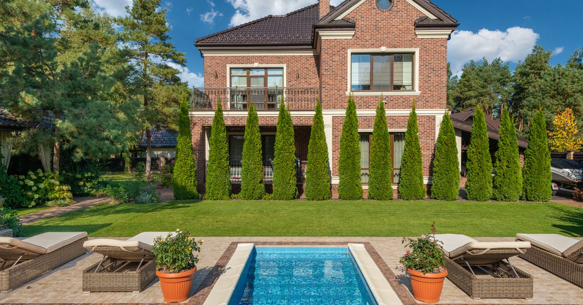 How far will my summer truffle and water go? - Facade of brick dwell villa with green bushes on lawn and sunbeds near swimming pool