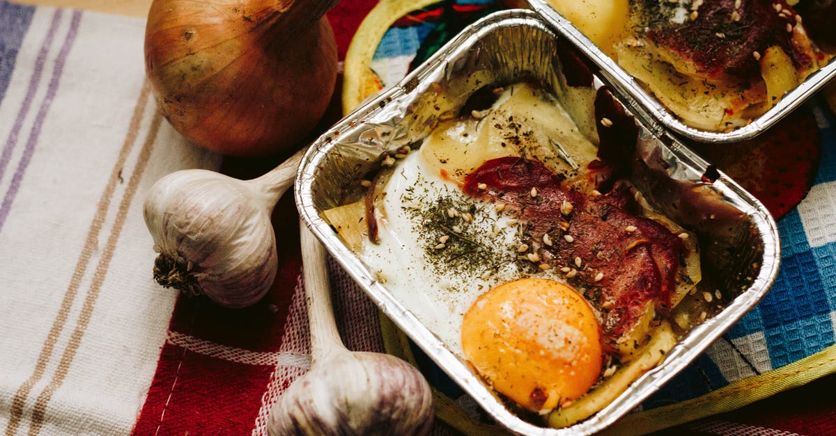 How hot does garlic need to get to lose its sharpness? - Cooked Food in Square Grey Tray Beside Garlics and Onion How hot does garlic need to get to lose its sharpness? - Cooked Food in Square Grey Tray Beside Garlics and Onion