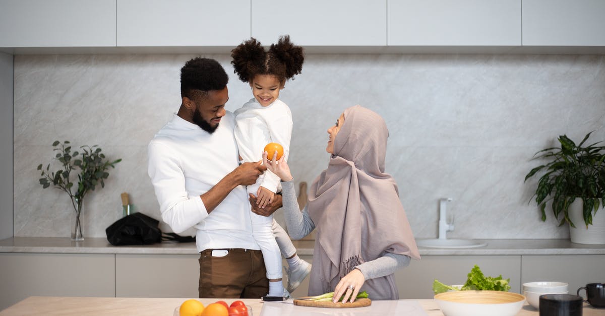 How is starch content of some vegetables reduced by cooking? - Happy young multiracial family in casual outfits standing near table in kitchen while cooking together at home How is starch content of some vegetables reduced by cooking? - Happy young multiracial family in casual outfits standing near table in kitchen while cooking together at home