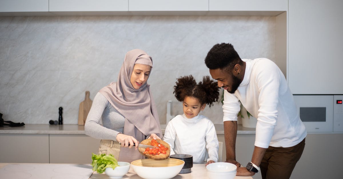 How is starch content of some vegetables reduced by cooking? - Delighted young diverse family standing near table in kitchen at home while cooking together at home How is starch content of some vegetables reduced by cooking? - Delighted young diverse family standing near table in kitchen at home while cooking together at home