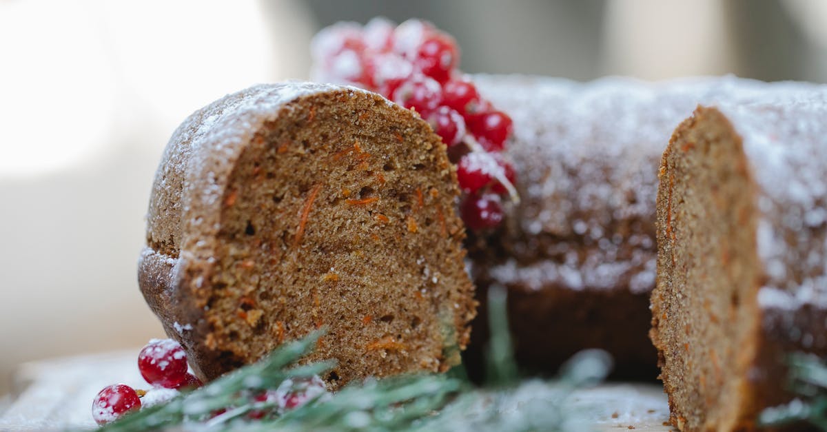 How long can a stacked carrot cake be stored - Appetizing homemade chocolate sponge cake with berries and rosemary sprig placed on table against blurred background