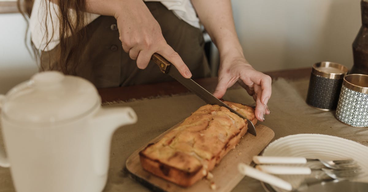 How long can I keep bread dough in the refrigerator? - Crop anonymous female with long dark hair in casual clothes cutting appetizing sweet banana bread while standing at table in kitchen How long can I keep bread dough in the refrigerator? - Crop anonymous female with long dark hair in casual clothes cutting appetizing sweet banana bread while standing at table in kitchen