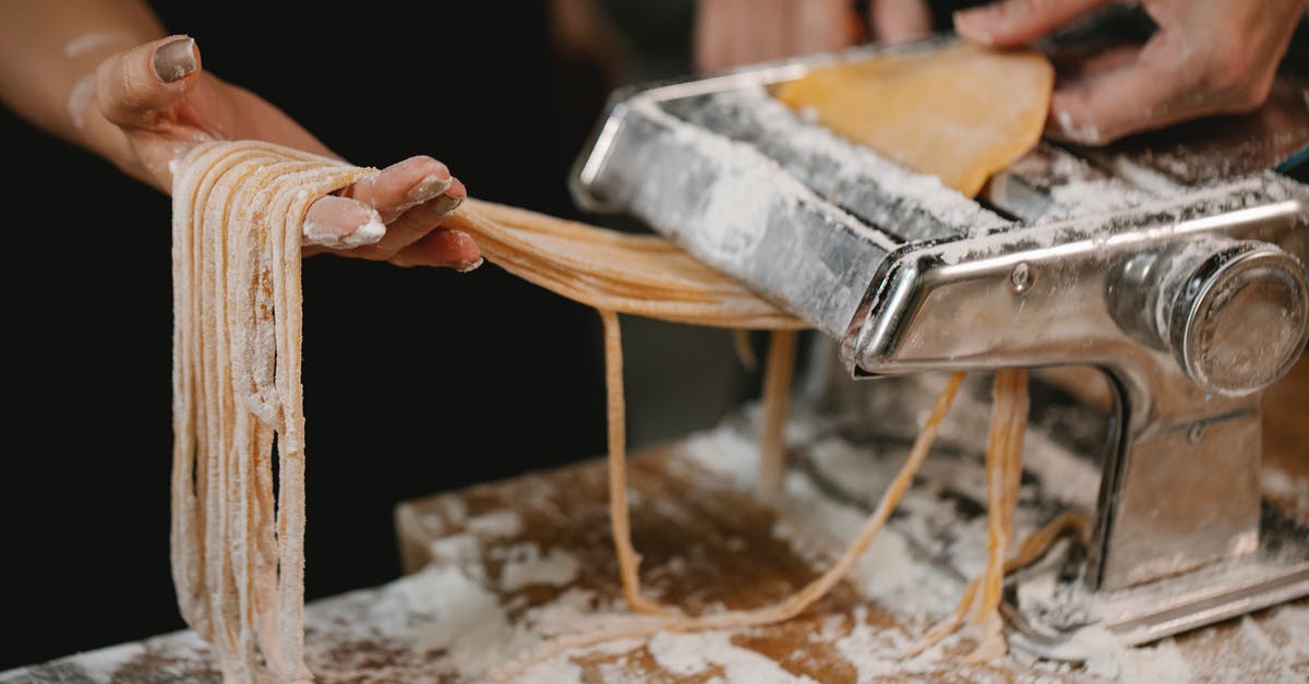 How long does cooked pasta last in the fridge? - Crop anonymous female producing long noodle with metal pasta cutter on wooden table covered with flour How long does cooked pasta last in the fridge? - Crop anonymous female producing long noodle with metal pasta cutter on wooden table covered with flour