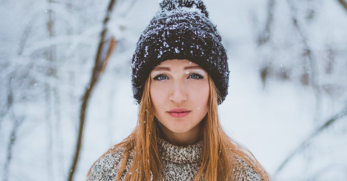 how long should I reheat frozen lasagna? - Woman in warm knitted sweater and hat standing in winter forest