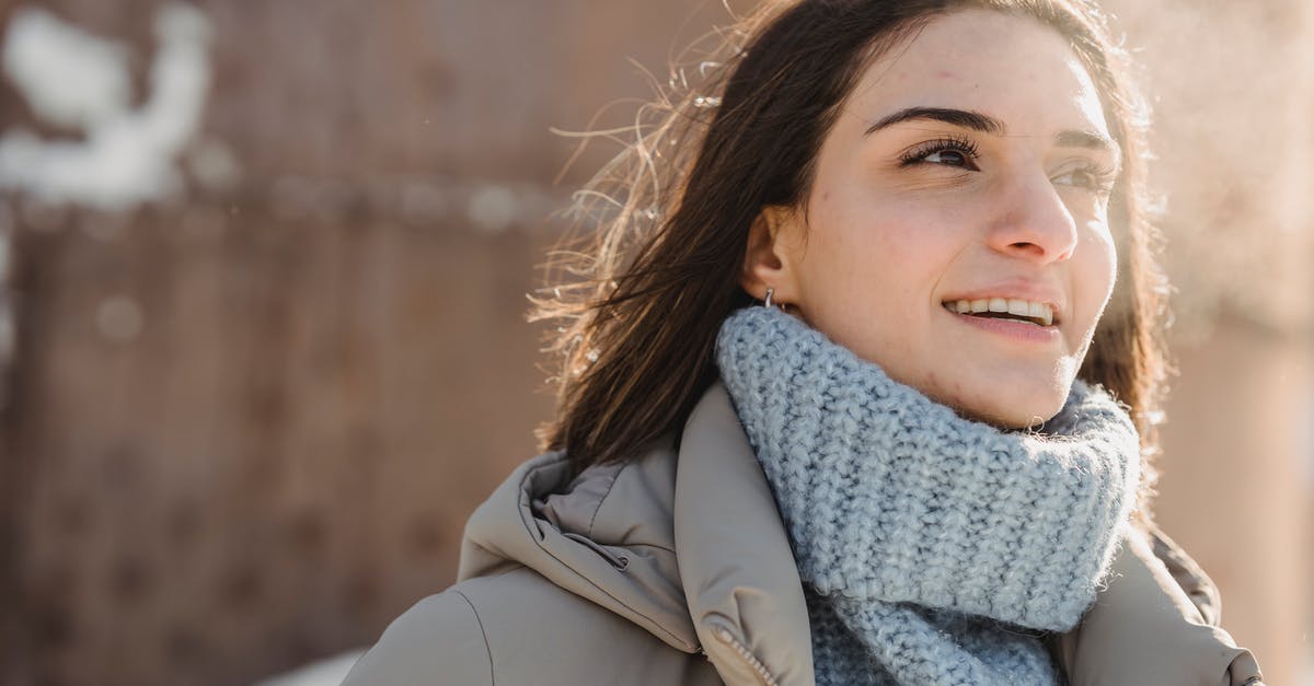 How long should I steam Artichokes? - Content young brunette in blue sweater and warm jacket standing on snowy city street on cold sunny day and looking away
