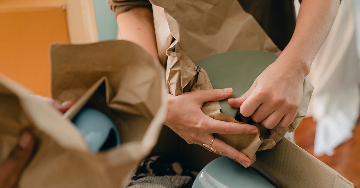 How many ceramic knives do I want? - Crop unrecognizable person packing ceramic tableware in parchment How many ceramic knives do I want? - Crop unrecognizable person packing ceramic tableware in parchment