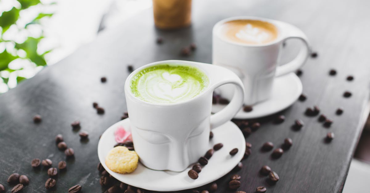 How much caffeine is in matcha powder? - From above of refreshing tasty matcha green tea latte and cappuccino in creative face shaped mugs placed on wooden table with scattered coffee beans How much caffeine is in matcha powder? - From above of refreshing tasty matcha green tea latte and cappuccino in creative face shaped mugs placed on wooden table with scattered coffee beans