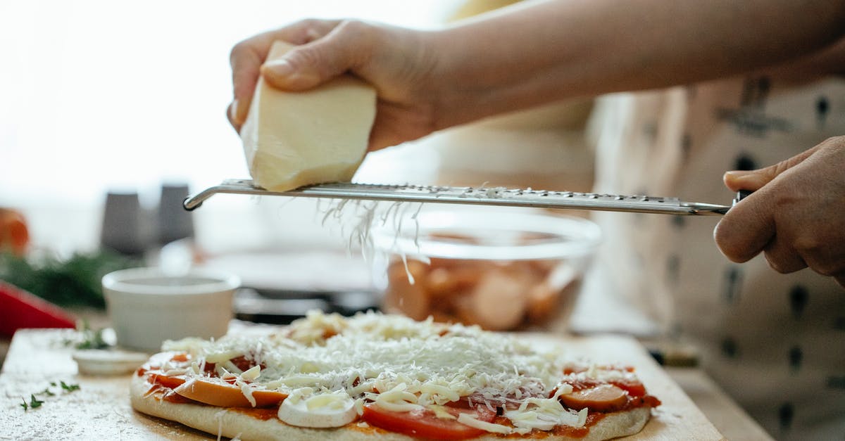How much foreign substance can I add to processed cheese? - Side view of crop unrecognizable person grating piece of hard cheese on palatable homemade pizza in kitchen at daytime How much foreign substance can I add to processed cheese? - Side view of crop unrecognizable person grating piece of hard cheese on palatable homemade pizza in kitchen at daytime