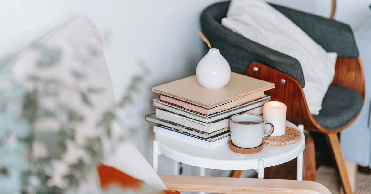 How much tea is ideal out of one tea bag? - Cup of tea and burning candle against books at home How much tea is ideal out of one tea bag? - Cup of tea and burning candle against books at home