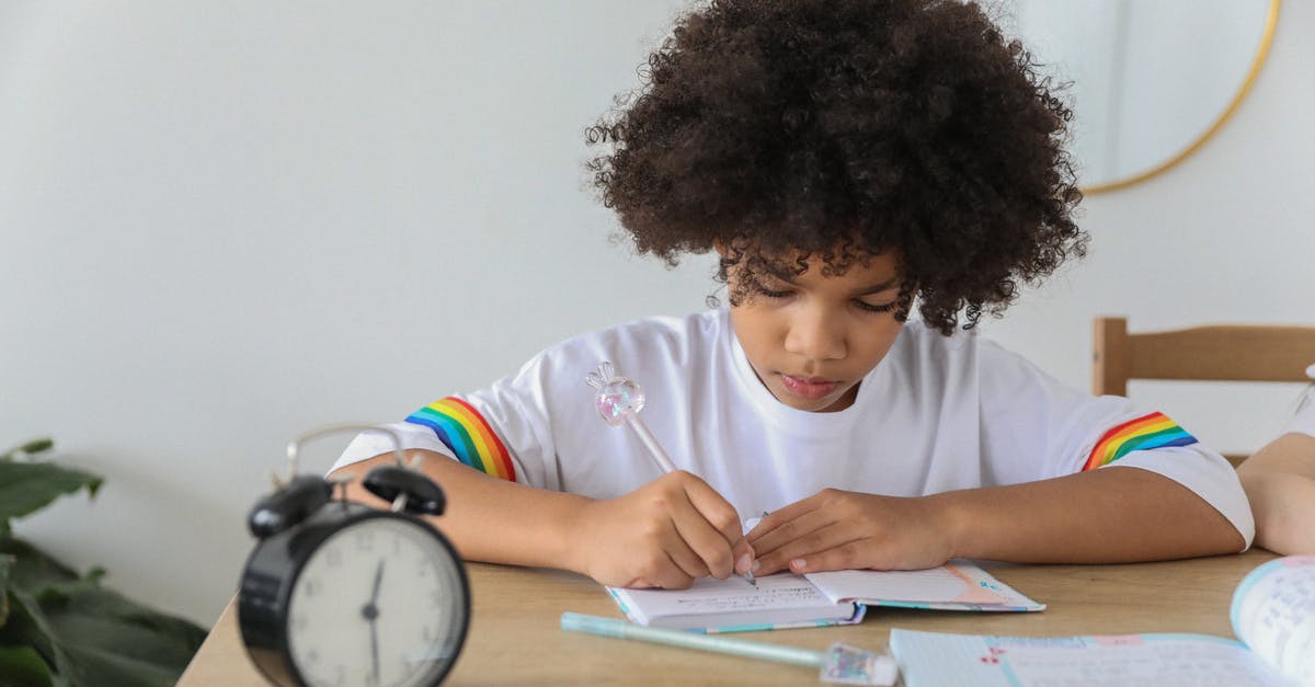 How much time does it take to boil salmon? - Concentrated African American child writing in notebook while studying at desk with alarm clock at home How much time does it take to boil salmon? - Concentrated African American child writing in notebook while studying at desk with alarm clock at home