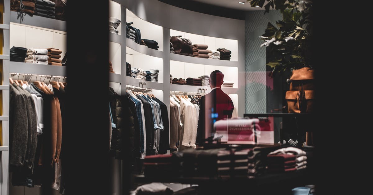 How should I choose corn? - Back view of faceless elegant male customer in suit choosing new clothes while standing near wardrobe in modern fashion boutique How should I choose corn? - Back view of faceless elegant male customer in suit choosing new clothes while standing near wardrobe in modern fashion boutique