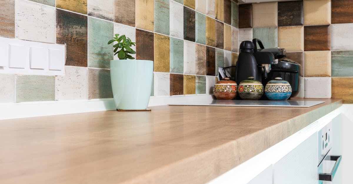 How should I clean anodized cookware? - Interior of light kitchen furnished with wooden counter with multicolored tiled backsplash and various dishware How should I clean anodized cookware? - Interior of light kitchen furnished with wooden counter with multicolored tiled backsplash and various dishware