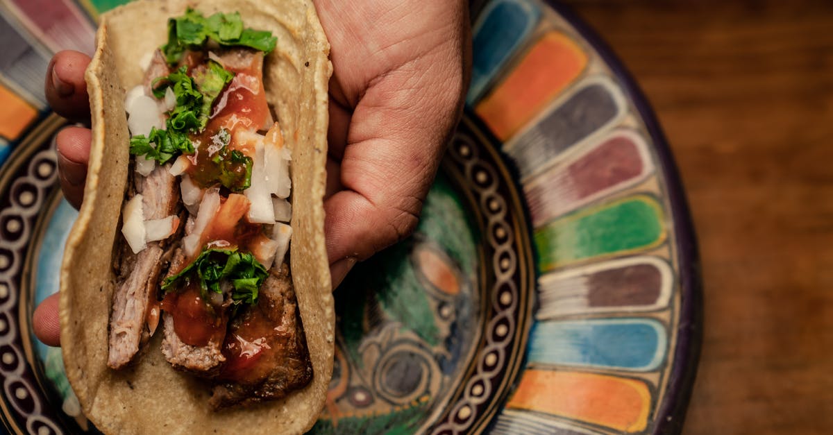 How should I layer the ingredients in a taco salad? - A Person Holding a Taco