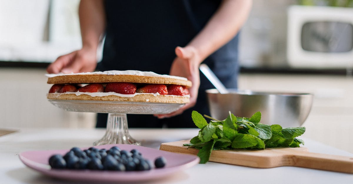 How should I organize making a cake days ahead? - Person Holding a Knife Slicing a Food on a White Plate