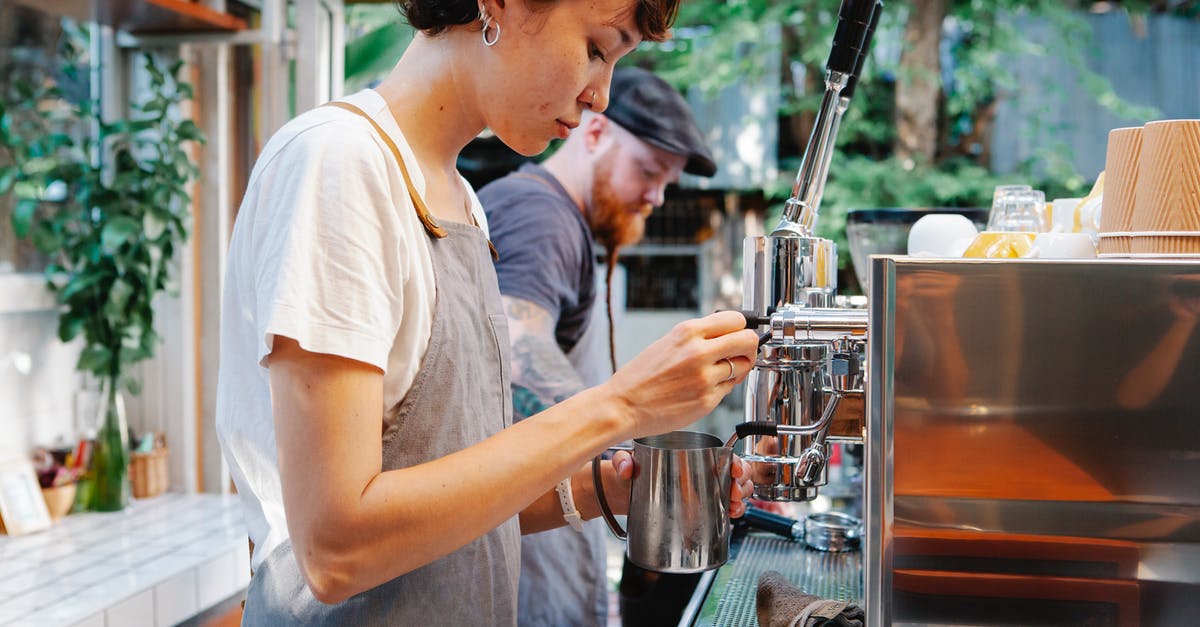 How should I prepare the coffee to be used in my tiramisu? - Young woman in apron using coffee machine How should I prepare the coffee to be used in my tiramisu? - Young woman in apron using coffee machine