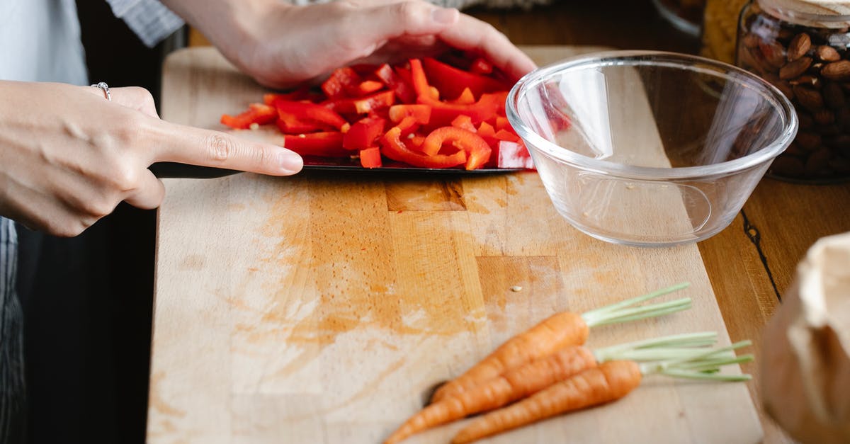 How should I store a cut bell pepper? - Crop unrecognizable woman cutting bell pepper in kitchen How should I store a cut bell pepper? - Crop unrecognizable woman cutting bell pepper in kitchen