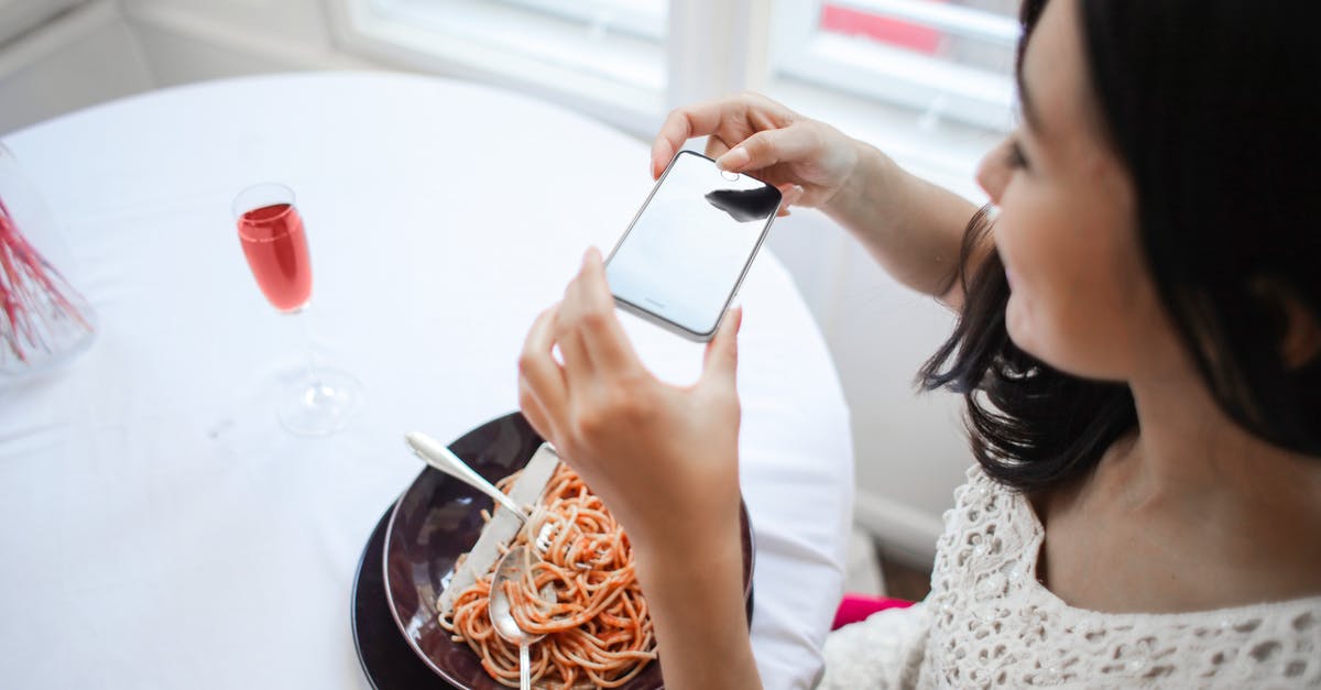 How should red wine be used in Spaghetti Bolognese? - Woman Taking A Photo Of Her Food How should red wine be used in Spaghetti Bolognese? - Woman Taking A Photo Of Her Food