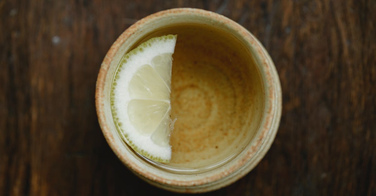 How to add lemon flavor to tea? - Overhead view of traditional ceramic Asian cup of fresh aromatic tea with lemon slice on wooden table How to add lemon flavor to tea? - Overhead view of traditional ceramic Asian cup of fresh aromatic tea with lemon slice on wooden table