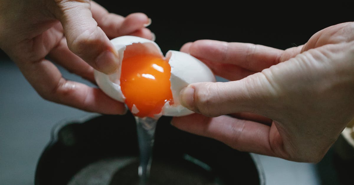 How to add panko to chicken without frying the chicken? - Crop anonymous chef breaking raw chicken egg in pan against dark blurred background How to add panko to chicken without frying the chicken? - Crop anonymous chef breaking raw chicken egg in pan against dark blurred background