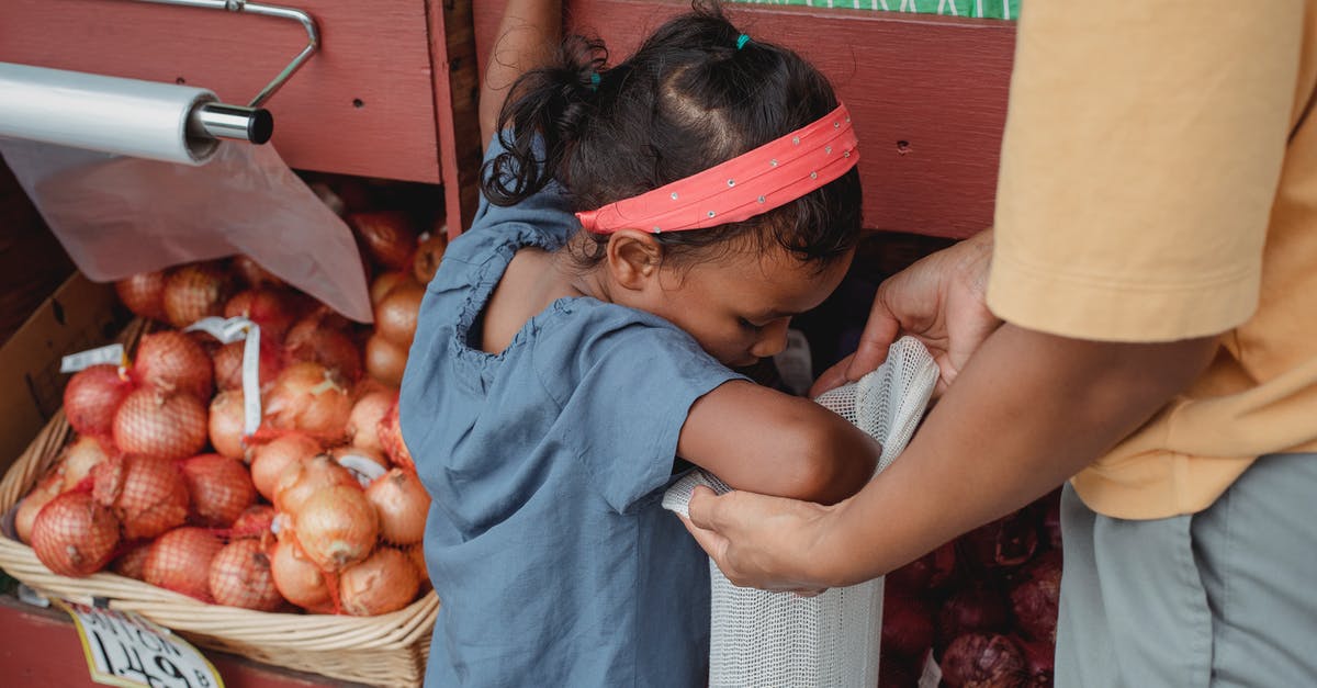 How to authenticate food products? - Asian girl buying vegetables with mother in local street market How to authenticate food products? - Asian girl buying vegetables with mother in local street market