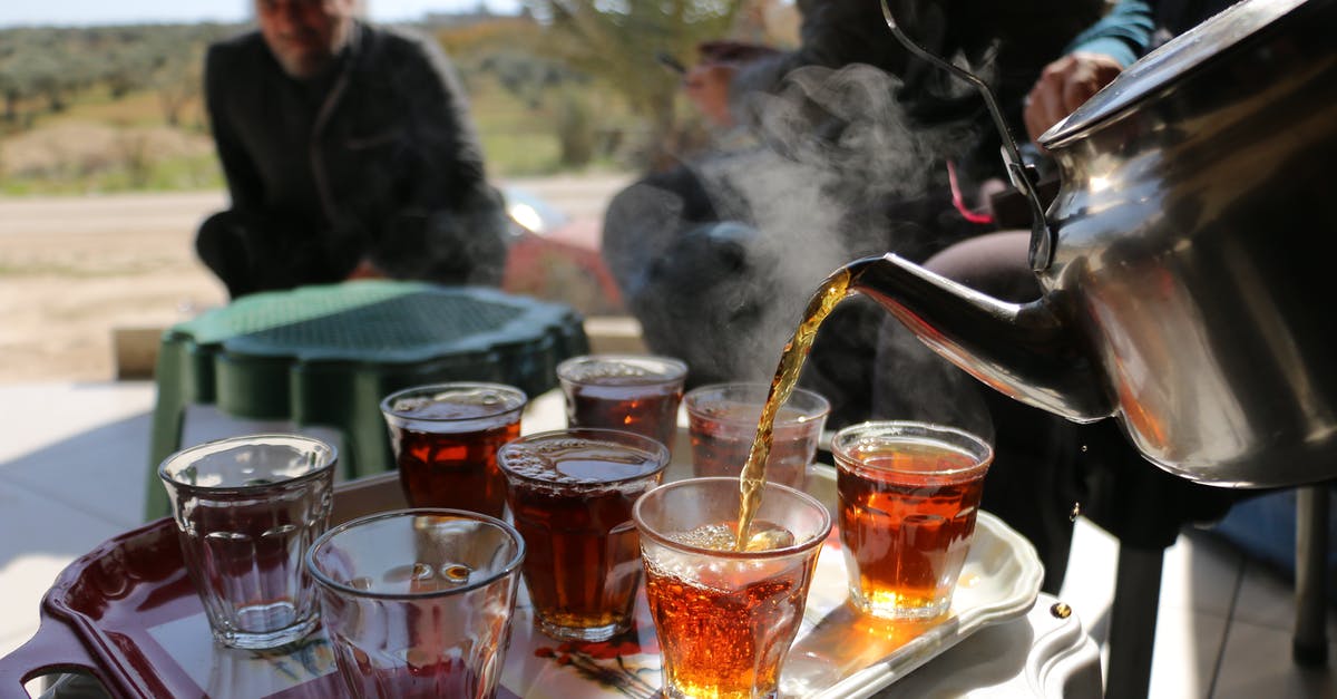 How to brew tasty tea with hard water - Man pouring tea from kettle into glass cups How to brew tasty tea with hard water - Man pouring tea from kettle into glass cups