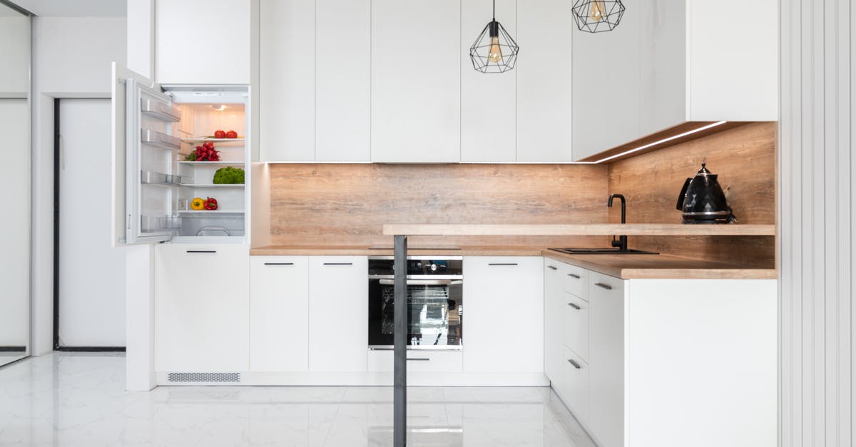 How to clean an electric kettle? - Interior of contemporary light kitchen with white furniture and modern appliances How to clean an electric kettle? - Interior of contemporary light kitchen with white furniture and modern appliances